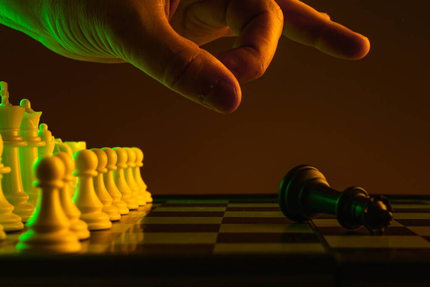 Κοντινό χέρι κάνει μια κίνηση, σαχ και ματ, σκάκι, σκακιέρα, παιχνίδι, αντιπαράθεση. σταδιοδρομία, προώθηση, κρίση εκκίνησης νίκη πτώχευσης - Φωτογραφία, εικόνα