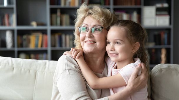 Happy mature grandmother and little granddaughter visualizing together - Фото, изображение