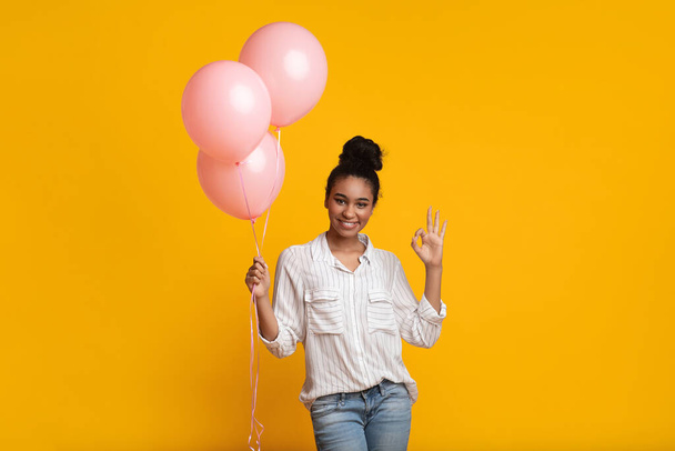 felice nero donna in posa con rosa palloncini e mostrando ok gesti
 - Foto, immagini