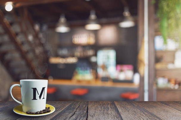 Hout tafelblad met waas in de coffeeshop. met witte koffiebeker, vintage kleurtoon. - Foto, afbeelding