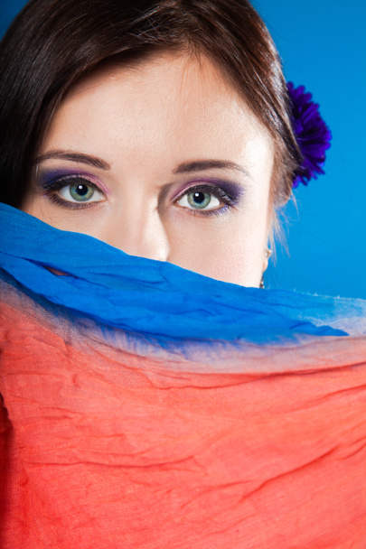 жінка ховає обличчя з хусткою на синьому
 - Фото, зображення