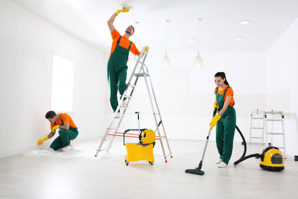 Team professioneller Hausmeister reinigt Raum nach Renovierung - Foto, Bild