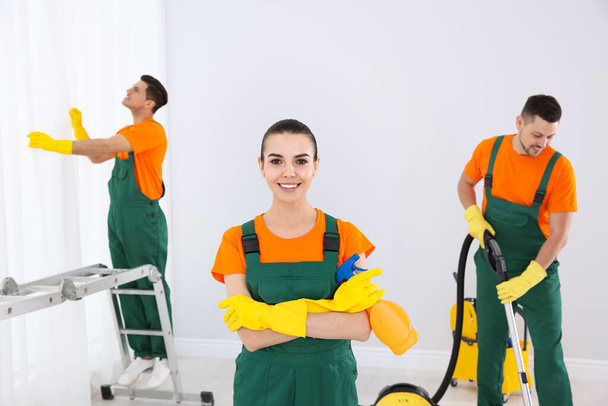 Team of professional janitors cleaning room after renovation - Photo, image
