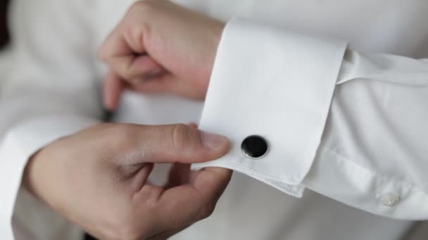 L'homme beau marié fixe ses poignets sur une veste avec des boutons de manchette. homme d'affaires - Séquence, vidéo