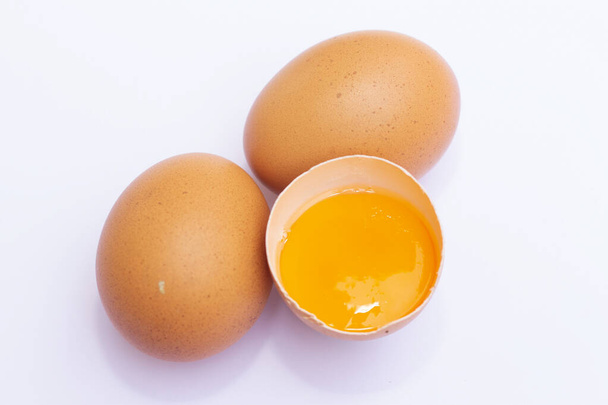 Τρία καφέ αυγά με ένα έχει σπάσει απομονώνονται σε λευκό φόντο - Φωτογραφία, εικόνα