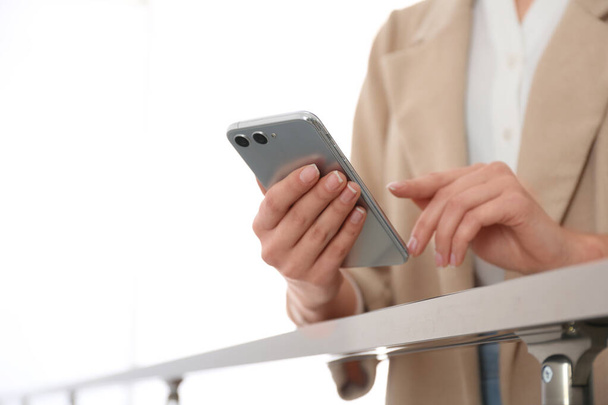 fiatal nő használ modern okostelefon beltéri, közelkép - Fotó, kép