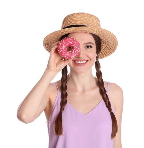 Beautiful young woman wearing stylish hat with donut on white background - Foto, imagen