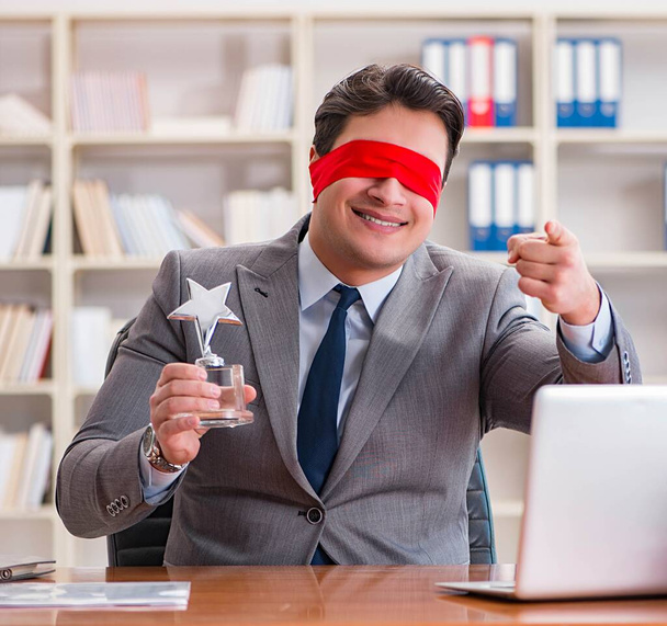 オフィスの机に座っているビジネスマンを盲目にする - 写真・画像