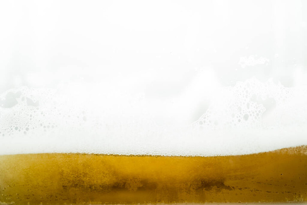Close up of cool lager beer splash isolated on white background with realistic bubbles & froth in glass. Pouring golden craft beer on front view wave curve shape texture foam for pub & bar menu design - Fotó, kép
