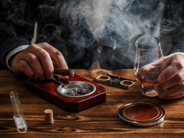 A well-dressed man at a bar drinks single malt whisky and smokes a cigar - Foto, Imagem