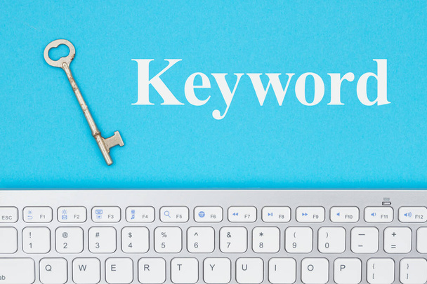 Mensaje de palabra clave con teclado gris con una tecla de esqueleto vintage en un papel azul
 - Foto, imagen