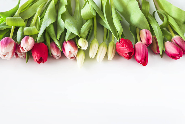 Hermoso ramo de tulipanes rosados, rojos y blancos sobre fondo blanco
 - Foto, imagen