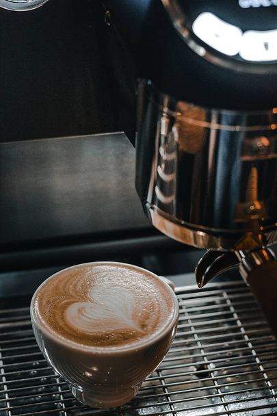 A Cup of Coffee with Latte Art on the Espresso Machine - Фото, зображення