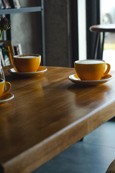 Gele koppen koffie op de koffietafel - Foto, afbeelding