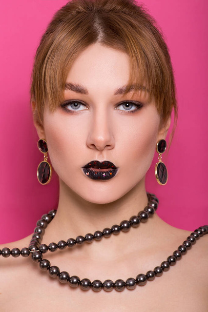A beautiful young girl of European appearance with beautiful make-up on a pink background. Beauty Shooting - Φωτογραφία, εικόνα