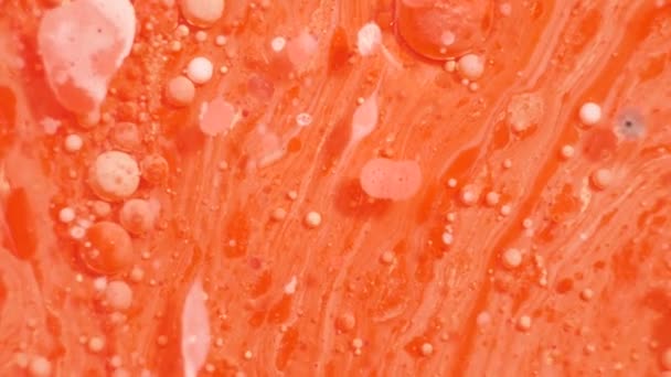 Barevné akrylové barvy se mísí do krásných vzorů. Olejové barvy korálů, oranžové, červené a jiné barvy se šíří po povrchu a mísí, vytváří úžasné textury a design. Abstraktní bubliny - Záběry, video