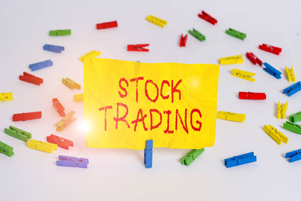 Word writing text Stock Trading. Business concept for the action or activity of buying and selling shares on market Colored clothespin papers empty reminder white floor background office. - Fotó, kép