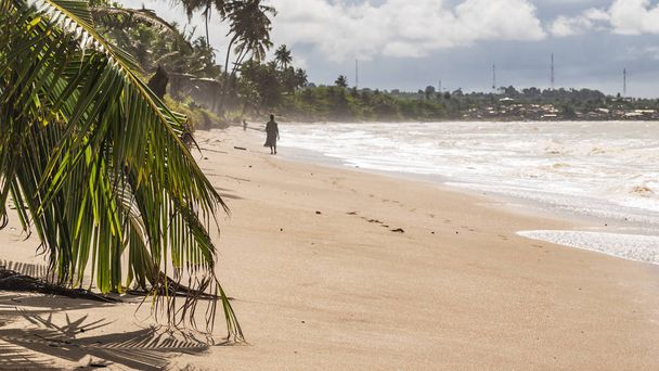 Les pêcheurs marchent sur la côte africaine de l'or où la mer est colorée par le sable. Axim beach est situé au Ghana Afrique de l'Ouest
. - Photo, image