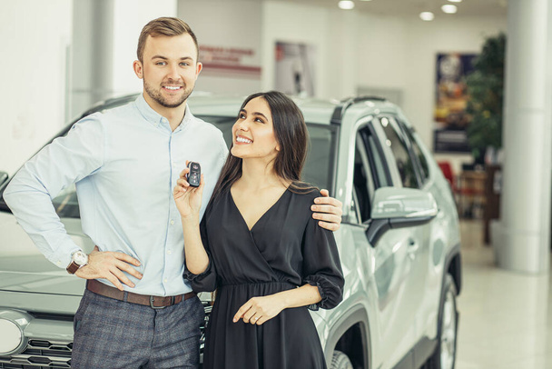 new owners of beautiful car in showroom - Photo, image