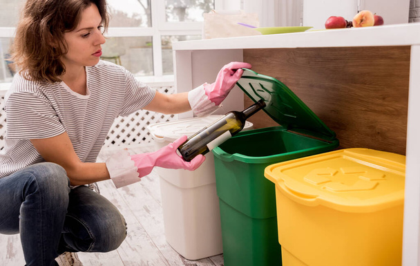 Młoda dziewczyna sortuje śmieci w kuchni. Koncepcja recyklingu. Zero odpadów - Zdjęcie, obraz