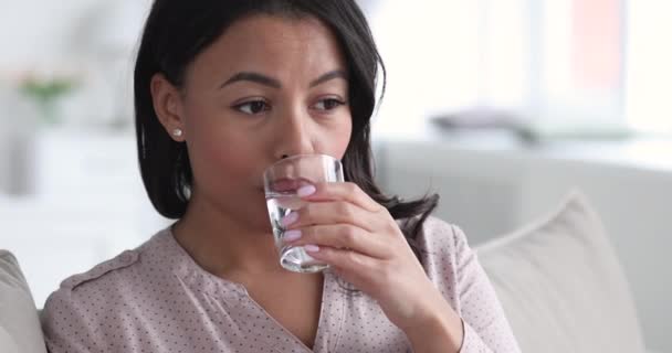 Υγιής αφρικάνικη νεαρή γυναίκα κρατά γυάλινο ποτό γλυκό μεταλλικό νερό - Πλάνα, βίντεο