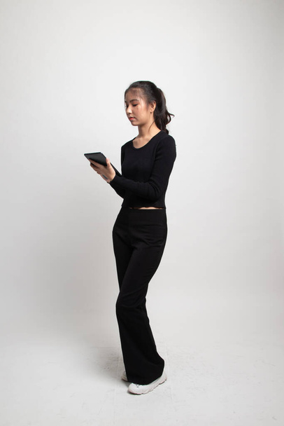 Full body of young Asian woman with a computer tablet on white background - Valokuva, kuva