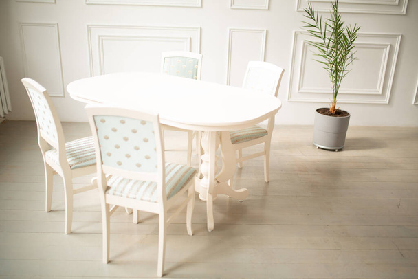 White tables and chairs for dinner in a classic interior. Upholstered chairs for comfortable sitting at the table - Fotó, kép