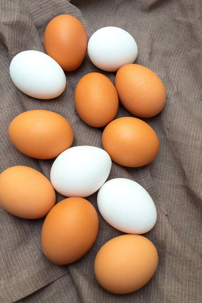 Muchos huevos blancos y marrones con servilleta textil. Pascua macro fondo vertical
. - Foto, Imagen