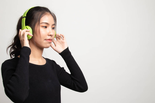 Pretty asian girl listening music with her headphones on white background - Fotografie, Obrázek