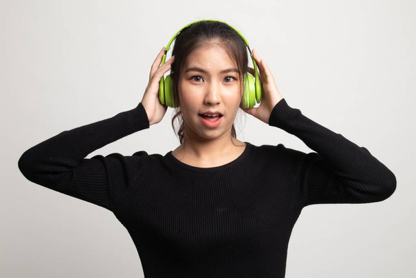 Pretty asian girl listening music with her headphones on white background - Fotoğraf, Görsel