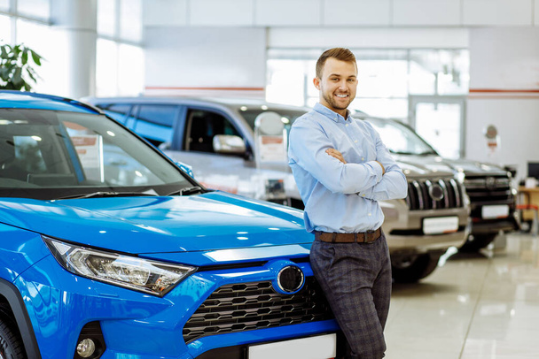 portrait of happy young guy after successful purchase of new car - 写真・画像