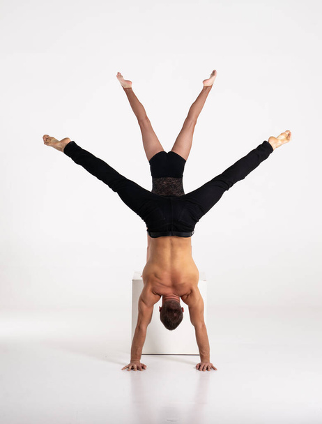 Good shaped man and woman practicing handstand exercise isolated on white background. Strength and motivation - Fotó, kép