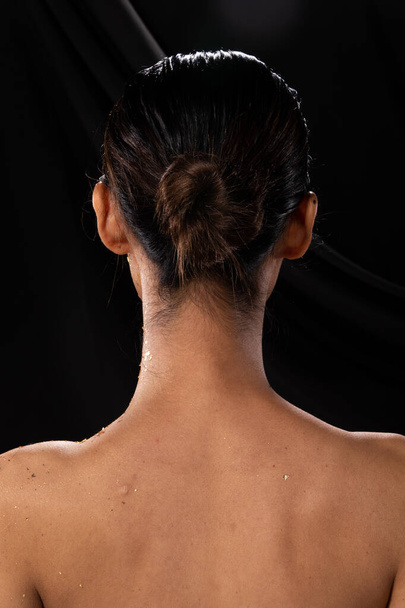 髪型を構成した後、アジアの女性のバックサイドビューヘアドア。レタッチなし。スタジオ照明ダークファブリックの背景、ラップはストレートブラックの髪を保つ - 写真・画像