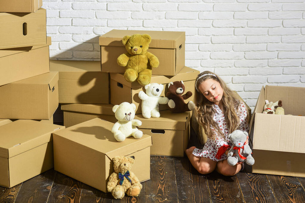 Feeling good at home. All she needs are toys. Home is where are my toys. Moving in. Sweet home. Girl child relaxing after unpacking boxes. Delivering service. Only necessary things. Playroom concept - Foto, afbeelding