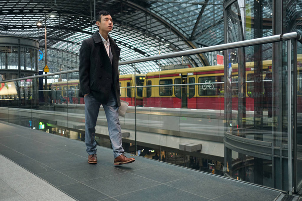 Νεαρός κομψός Ασιάτης επιχειρηματίας με αυτοπεποίθηση περπατώντας μέσα από σύγχρονο σταθμό του μετρό - Φωτογραφία, εικόνα