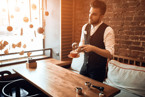 young professional barista with a holder and a cup showing workshop - Foto, immagini