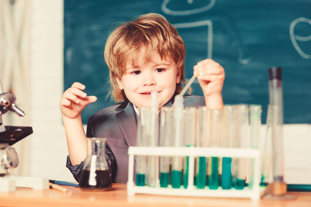 Kid study chemistry. Biotechnology and pharmacy. Genius pupil. Chemical analysis. Science concept. Wunderkind experimenting with chemistry. Boy use microscope test tubes chemistry school classroom - Фото, зображення