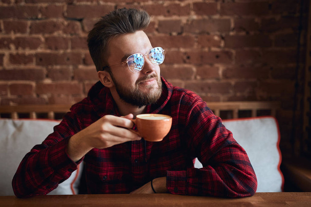 cheerful smiling man holding a cup of tea and looking aside, away - Foto, Imagem