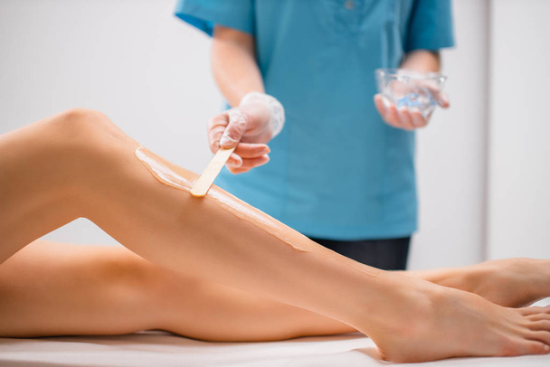 Aplicar una crema hidratante especial en las piernas antes de usar la máquina ipl - Foto, imagen
