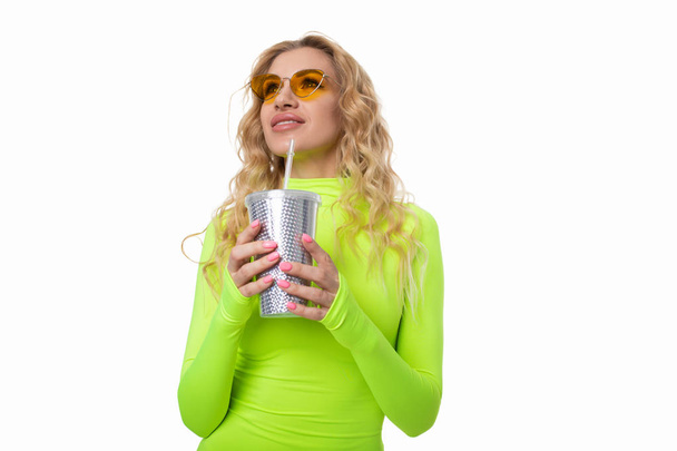 The blonde in a lemon-colored dress holds a bright glass for a cocktail - Fotoğraf, Görsel