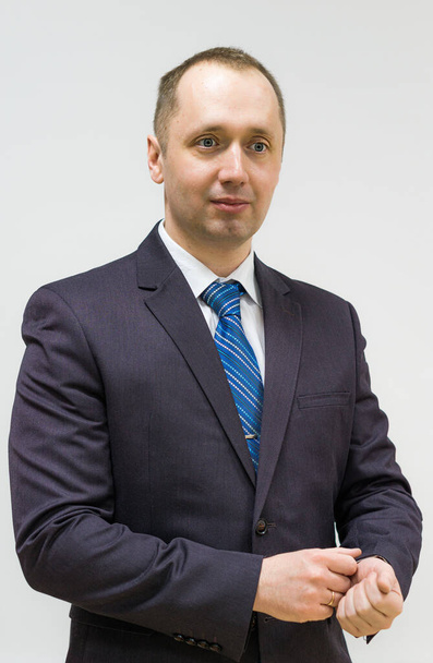 portret van een zelfverzekerde, doelbewuste, succesvolle zakenman in grijs pak en blauwe stropdas - Foto, afbeelding