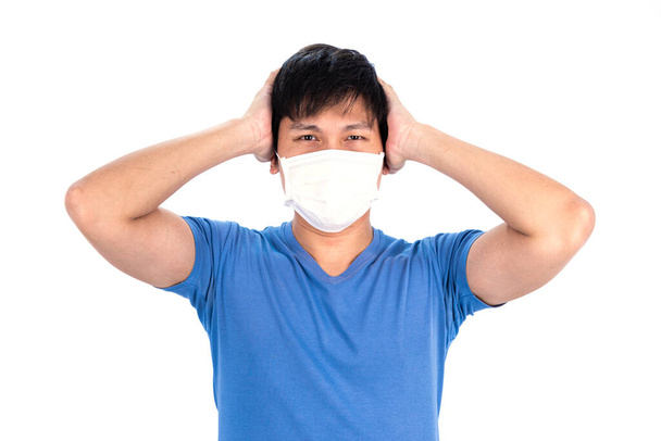 Azji młody człowiek w niebieskim t-shirt top i maska medyczna do ochrony COVID-19 z izolowanym na białym tle koncepcji. - Zdjęcie, obraz