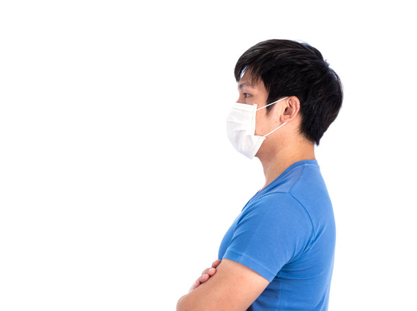 Asijský mladý muž v modrém tričku top a lékařské masky na ochranu COVID-19 s izolované na bílém pozadí koncept. - Fotografie, Obrázek
