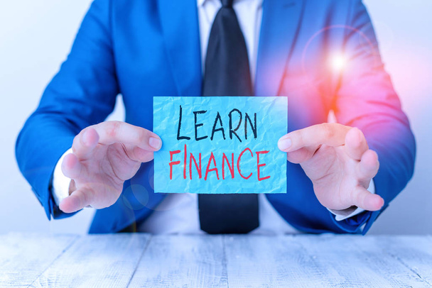 Text sign showing Learn Finance. Conceptual photo study which figures out how showing and business uses money Man holds empty paper with copy space in front of him Copy Space. - Zdjęcie, obraz