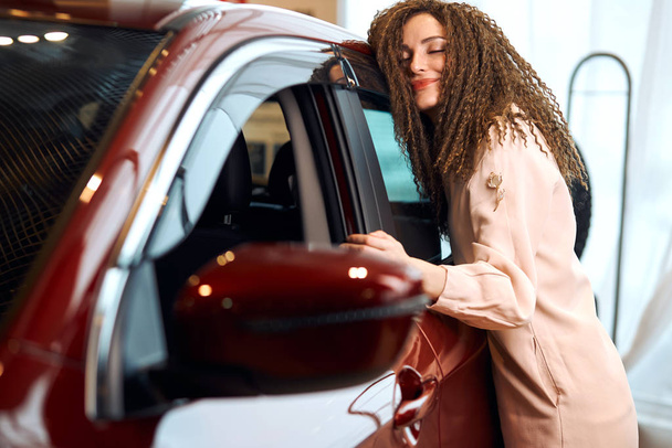 Cheerful young awesome stylish girl hugging her new car - Photo, image