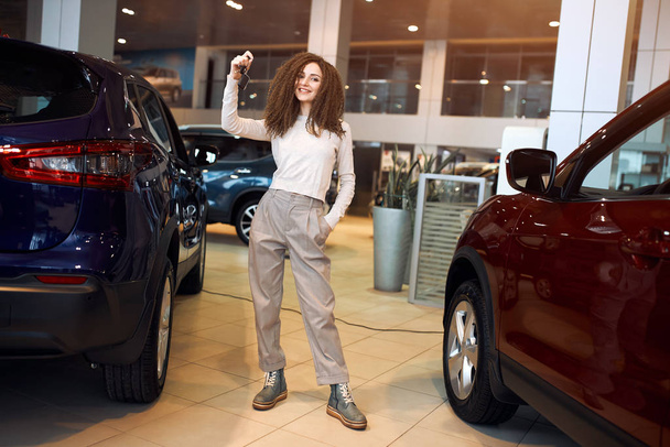 attractive lovely girl standing at dealership with keys - Фото, зображення