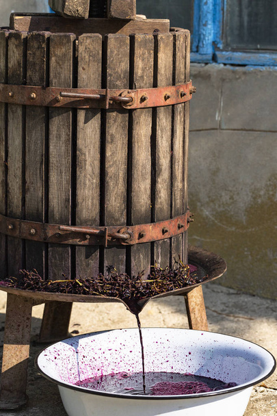  Výroba vína. Technologie výroby vína v Moldavsku. Starověká lidová tradice zpracování hroznů. Stlačovač se používá k lisování vína.. - Fotografie, Obrázek