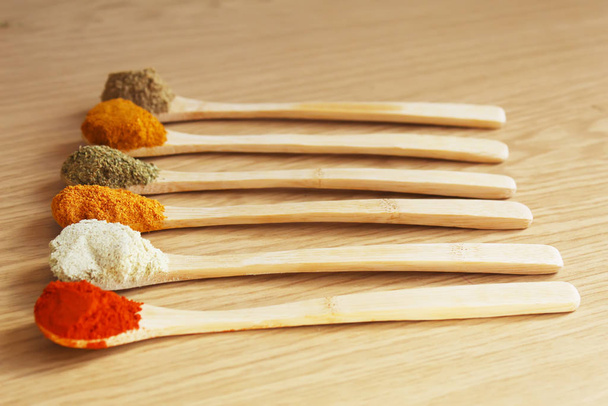 spices and herbs in wooden spoons. Seasonings for food. Selective focus. - Photo, Image