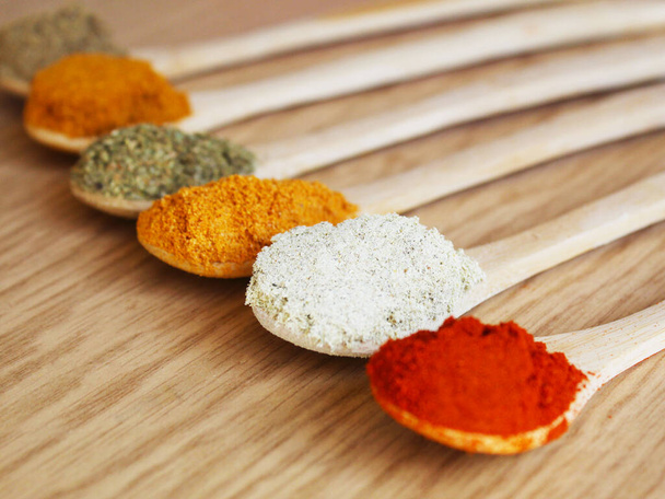 spices and herbs in wooden spoons. Seasonings for food. Selective focus. - Foto, afbeelding