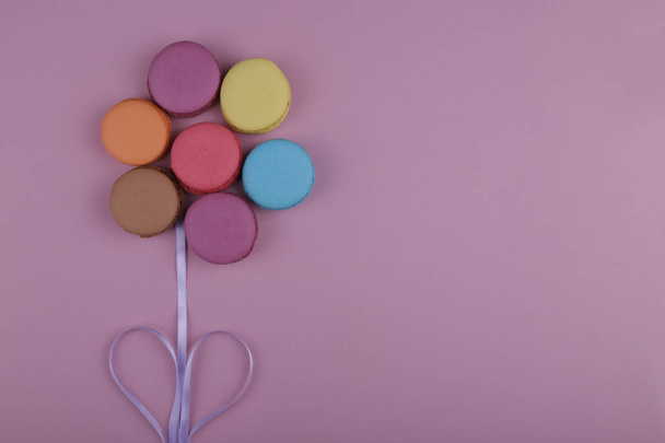 colored french macaroons in the form of a flower on a pink background - Valokuva, kuva